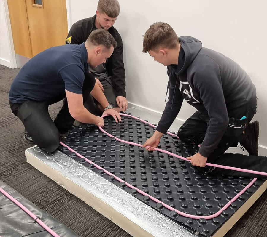 Electric underfloor heating installer in London laying heating mat and routing floor sensor